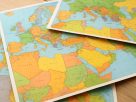 Colorful maps depicting Europe and the Middle East spread out on a surface